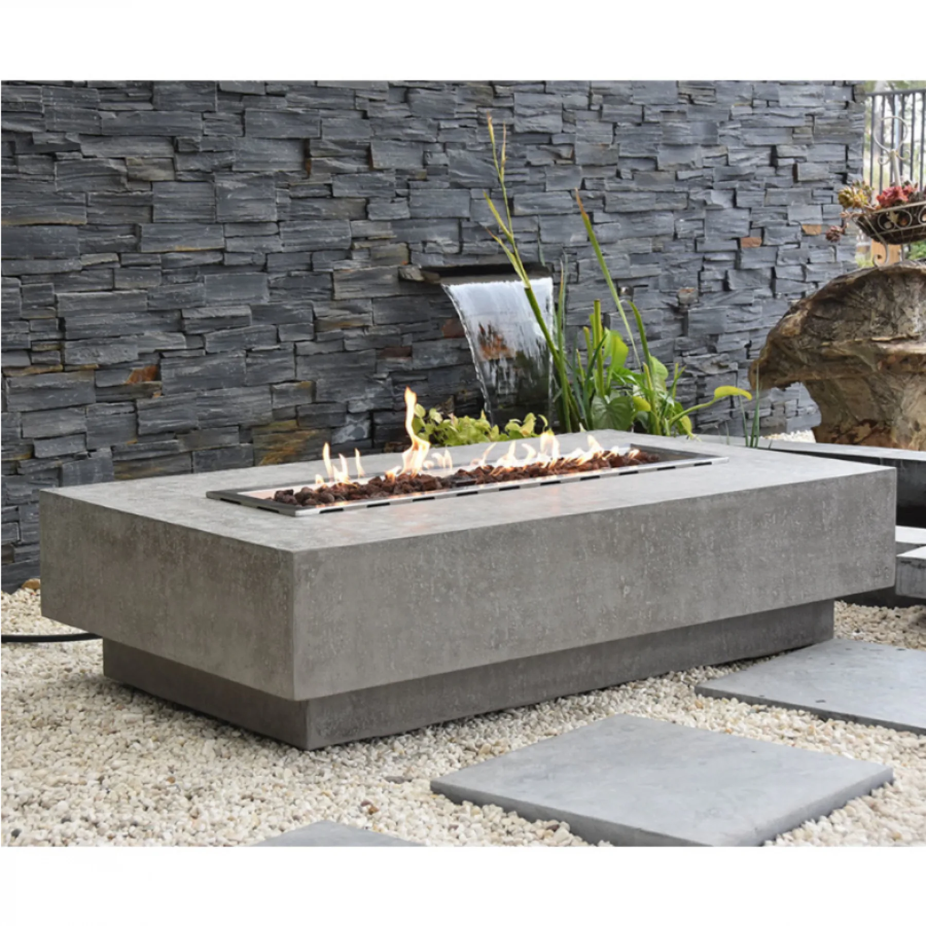 A concrete fire pit table set on a stone terrace