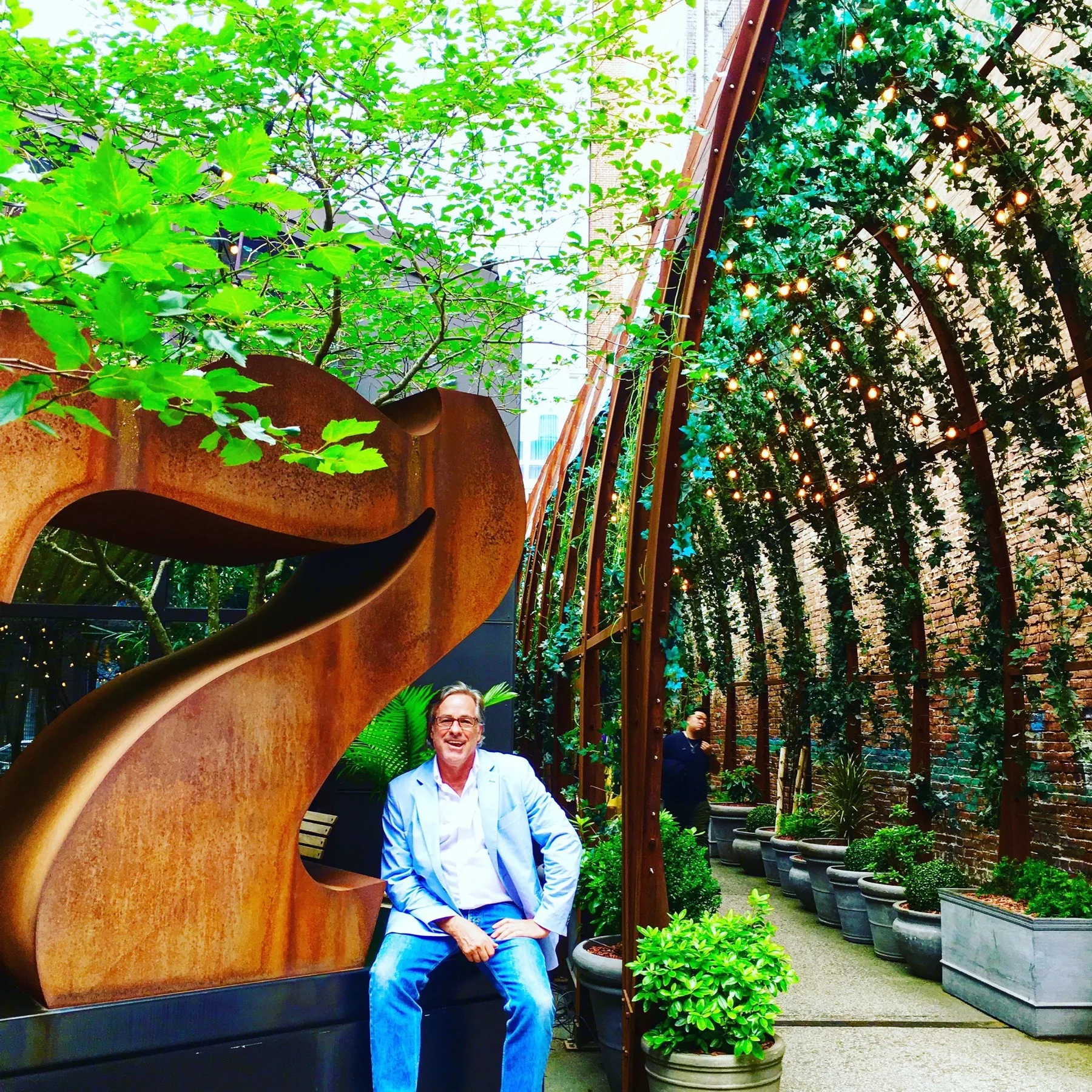 Jeffrey Allis within a living green tunnel of plants